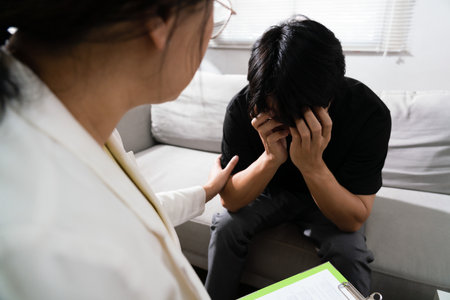 Psychologist woman giving encouraging depressed man with mental health problem in therapy center.の写真素材