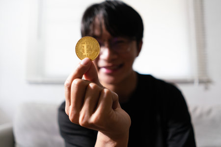 Young man holding golden cryptocurrency bitcoin for future lifestyle with virtual electronic money.