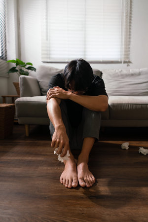 Man with mental health problem sitting on the floor to crying with stressed and depressed emotion.の写真素材
