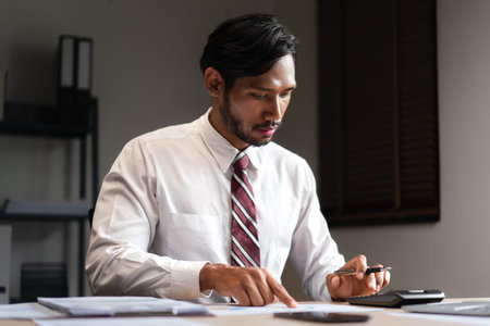 Businessman using calculator to checking marketing graph document and analyzing strategy of startup.