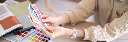 Fashion designer women looking on color swatch sample to design clothes for creative new collection.の写真素材