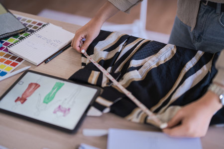 Fashion designer women use measure tape to measuring size and checking details new collection dress.