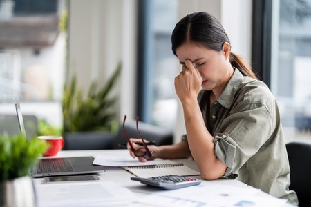 Asian casual businesswoman stressed and fatigue while overwork from analysis finance of new startup.の写真素材