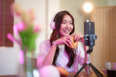 Young asian vj women in headphone using smartphone to recording video and speaking morning talks...