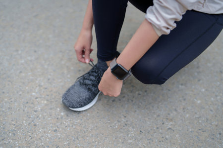 Young asian sporty women tying shoelaces running shoes to getting ready for run training and jogging...