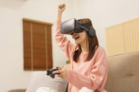 Lifestyle at home concept, LGBT lesbian women playing game with joystick and making winner gesture.の写真素材