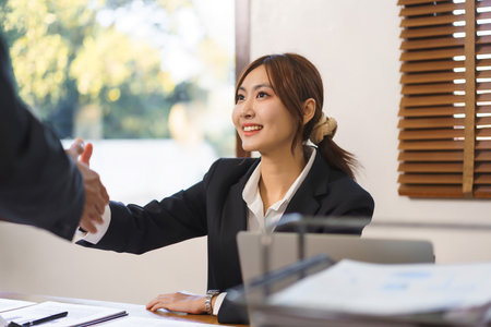 Business analysis concept, Businesswoman and senior business shaking hand after deal work together.の写真素材