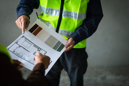 Two engineers working to discussing and inspecting about blueprint of building in construction site.の写真素材