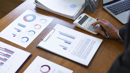 Business analysis concept, Senior businessman use calculator to calculate business cost and profit.