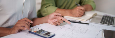 A professional engineering team working on cost estimation and resource allocation for a building project.の写真素材