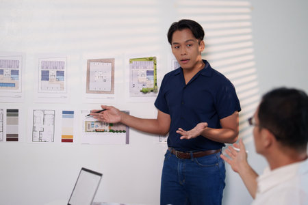 A group of engineers reviewing structural designs and material specifications at a meeting table.の写真素材