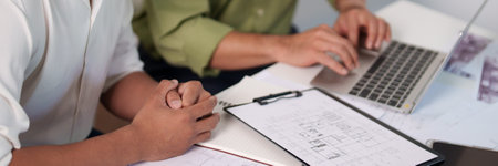 A professional engineering team working on cost estimation and resource allocation for a building...