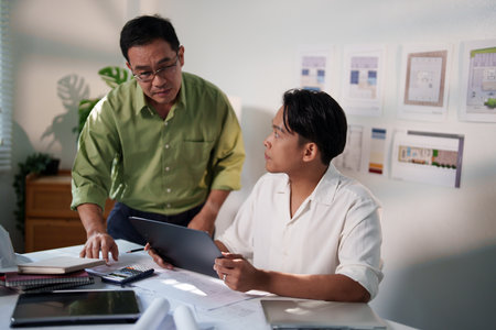 A detailed discussion between engineers about building requirements and material optimization for a large project.の写真素材