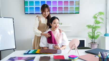 Young Asian women receiving personal color analysis from a stylist. Discovering best color palette for clothes and makeup. Expert consultation to enhance natural beauty.の写真素材