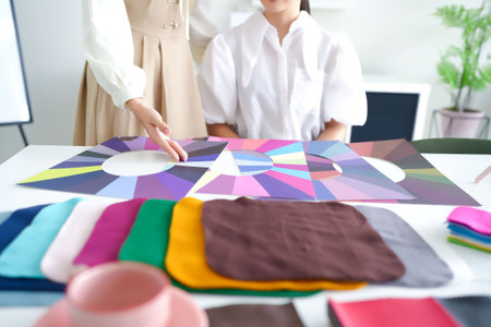 Asian women receiving personal color analysis. Consultants assist in selecting the perfect seasonal palette for wardrobe styling and makeup to enhance natural beauty and complexionの写真素材