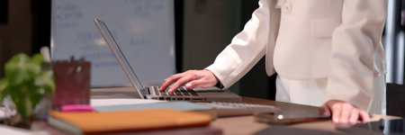 Adult Asian women using laptop in modern office environment Professional woman typing on keyboard at...