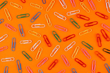 paper clips on orange paper sheet backgroundの写真素材