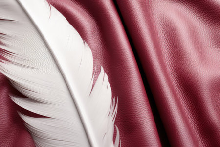 close up of white feather on pink leather background. soft focus.の素材