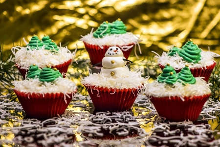Christmas Cupcakes with a snowman and Christmas tree decorationsの写真素材