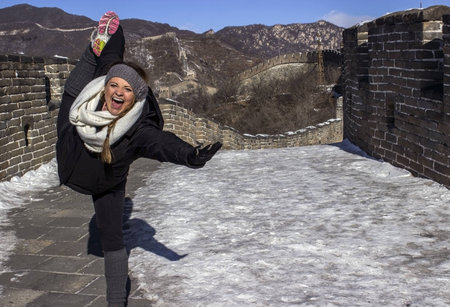A Female Tourist Practicing Yoga on the Great Wall of Chinaの写真素材