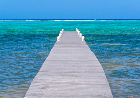boardwalk leads out to the ocean, calm and relaxing viewの写真素材