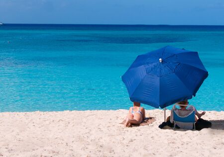 Relaxing on the beach with blue umbrellaの写真素材