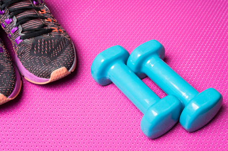 Weights and running shoes on an exercise matの写真素材