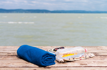 Neatly packed summer essentials with a lake in the backgroundの写真素材