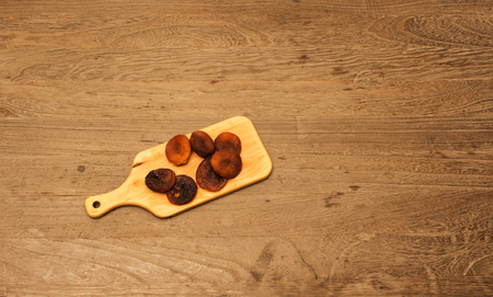 Dried apricot in wood platter on wood tableの写真素材