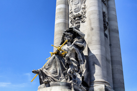 Statue of woman holding golden sword at Pont Alexandre III in Parisの写真素材