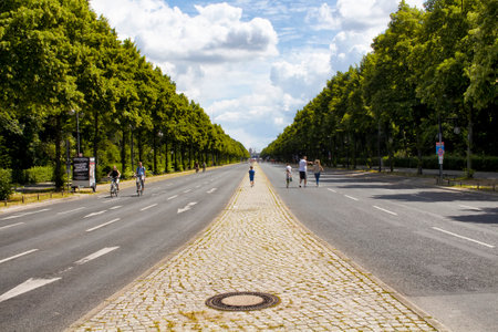 BERLIN - JULY, 2016: Family walks and people ride bikes on street called "StraÃï¿½e des 17. Juni" at very big park "Tiergarten" in Berlin.のeditorial素材