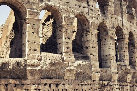 Close up view of Colosseum in Rome. Monumental 3-tiered Roman amphitheater once used for...