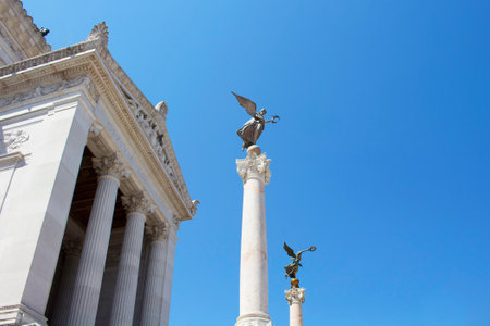 View of winged women statues on top of columns at Altar of the Fatherland in Rome. Grand marble, classical temple honoring Italy's first king & First World War soldiers.のeditorial素材