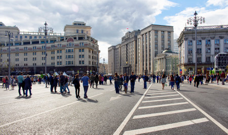 Local people walk in city center at the time of Moscow city day celebrations and festival. Roads are closed for the event. It is around Theatre Square. The state Duma building is in the view.のeditorial素材