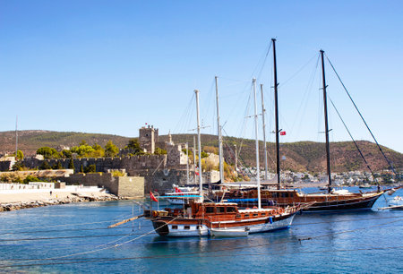 Luxury yachts (sailing boats) parked on turquoise water in front of Bodrum castle. The image shows Aegean and Mediterranean culture of coastel lifestyle.のeditorial素材