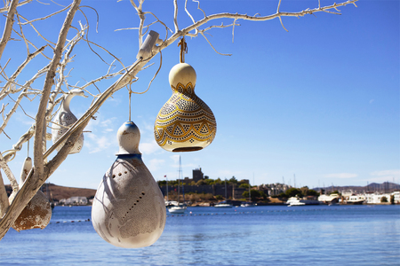 Handmade lamps made of water pumpkin (Calabash) at seaside of Bodrum city in Turkey. Yachts, Aegean sea and Bodrum castle are in the background. These lighting is used in the region for decoration.の写真素材