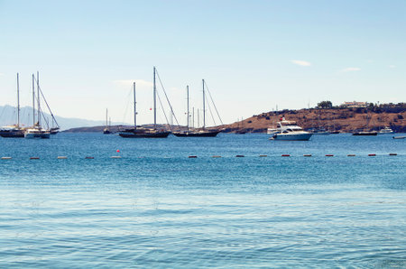 Luxury yachts (sailing boats) parked on turquoise water in front of Bodrum castle. The image shows Aegean and Mediterranean culture of coastal lifestyle.のeditorial素材