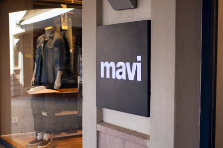 Close up view of famous fashion brand signage and its store window in the background.