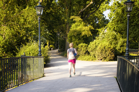 Woman out of gym walks at Spee'scher Graben (a park) in Dusseldorf. The image communicates lifestyle and culture in the city.の写真素材