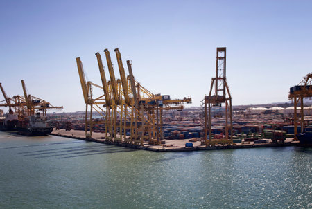 Aerial view of big, giant cranes at Barcelona port. Many containers and two ships are also in the scene. It's one of the most important commercial harbors in Europe and Mediterranean region.のeditorial素材