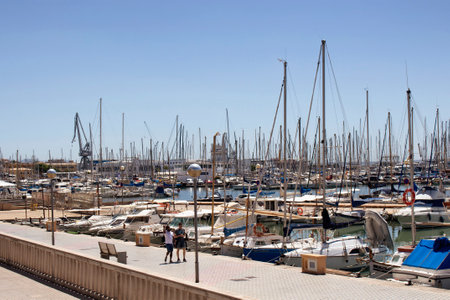 Two men walk at Palma de Mallorca marina in sunny summer day. It's a resort city and capital of the Spanish island of Majorca in the western Mediterranean.のeditorial素材