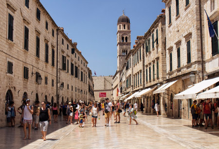 Many tourists walk on one of the major streets (Stradun) in Dubrovnik old town on sunny summer day.のeditorial素材