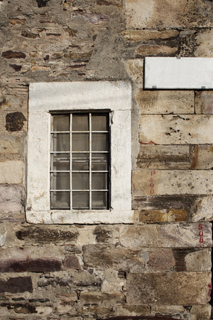 View of window and street sign on a stone wall in Cunda (Alibey) island.の写真素材