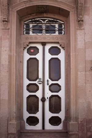 Close up view of old, blue wooden door and stone wall of historical house in Cunda (Alibey) island. Image shows Aegean architectural style.の写真素材