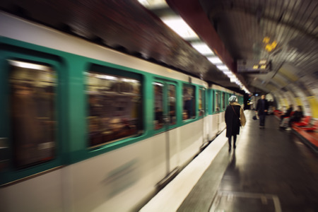 Blurry motion image of woman walking and a train in subway station in Paris.の写真素材