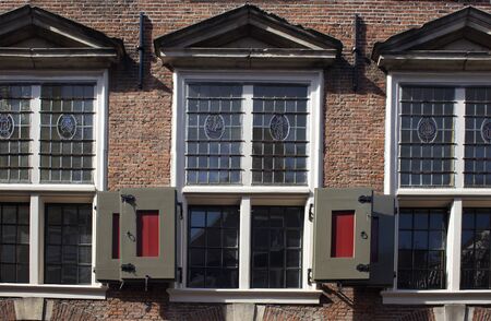 Close up view of historical, traditional windows and shutters showing Dutch architectural style in...
