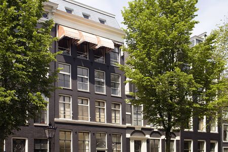 View of historical, traditional and typical buildings showing Dutch architectural style and trees in...