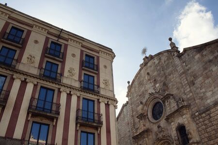 Bottom view of old, historical, traditional building and church on famous "La Rambla" street in Barcelona showing Spanish / Catalan architectural style and culture. It is a sunny summer day.の写真素材