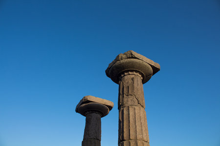 View of historical ruins with clear, blue sky background captured in the temple of Athena at the ancient city of Assos located in Behramkale, Turkeyの写真素材