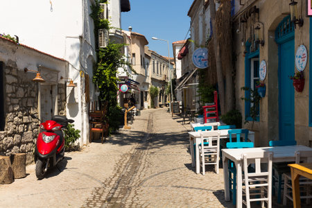 View of a narrow street and old, historical, traditional stone houses in famous, touristic Aegean town called Alacati. It is a village of Cesme, Turkey. It is a sunny summer dayのeditorial素材